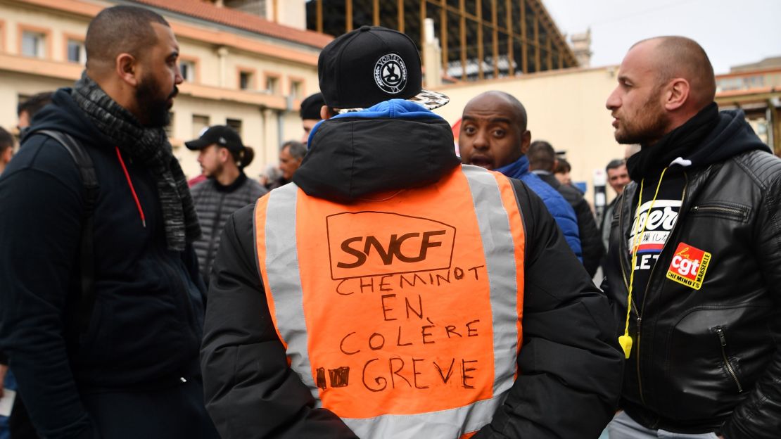 A man wearing a jacket reading "angry railway worker on strike" at a Marseille train station on Tuesday.