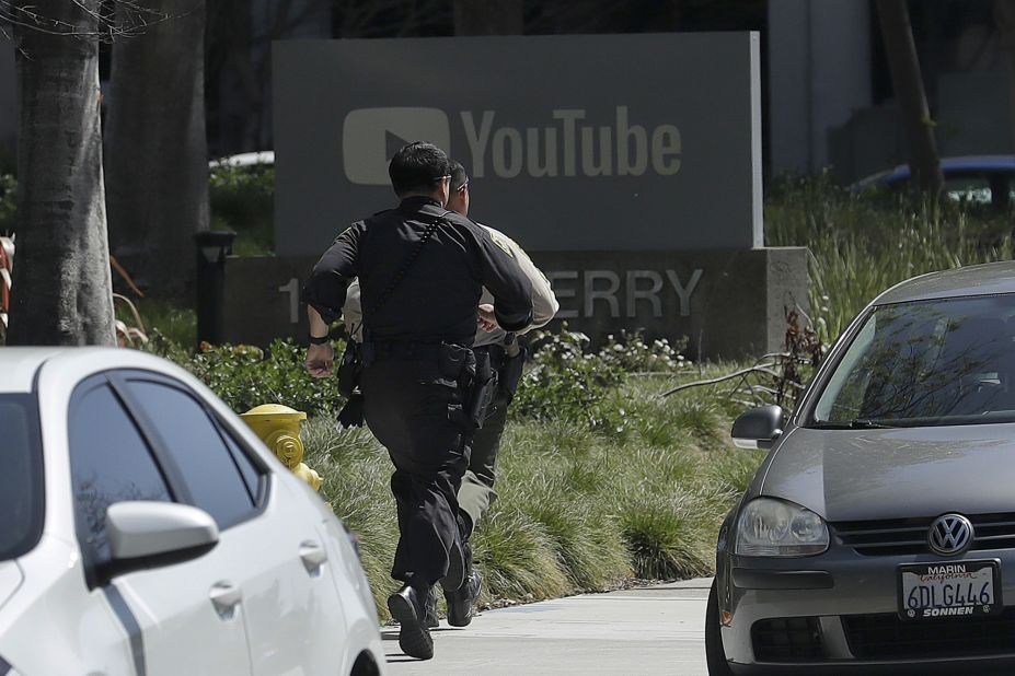 Officers run toward the building after the shooting.