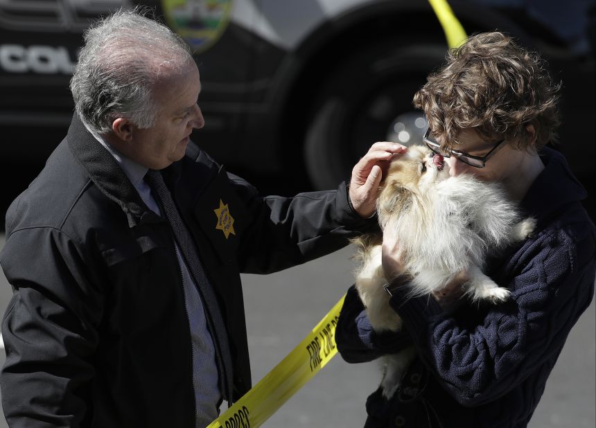Burlingame Police Chief Eric Wollman hands a dog named Kimba to a man who didn't give his name but said he worked for YouTube.
