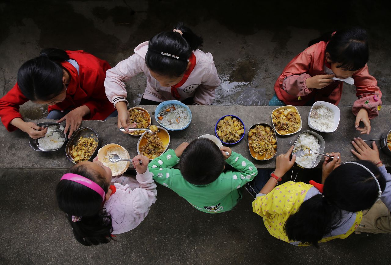 Students eat a free lunch, consisting of rice and traditional dishes, at Yuanbao school in Guizhou, a mountainous province in southwest  China. Free lunch has been sponsored by the central government since 2011 to improve students' nutrition. Previously, students in poor rural communities either didn't eat or ate only small amounts of food. School feeding programs are ubiquitous across high-, middle- and low-income countries, experts say.