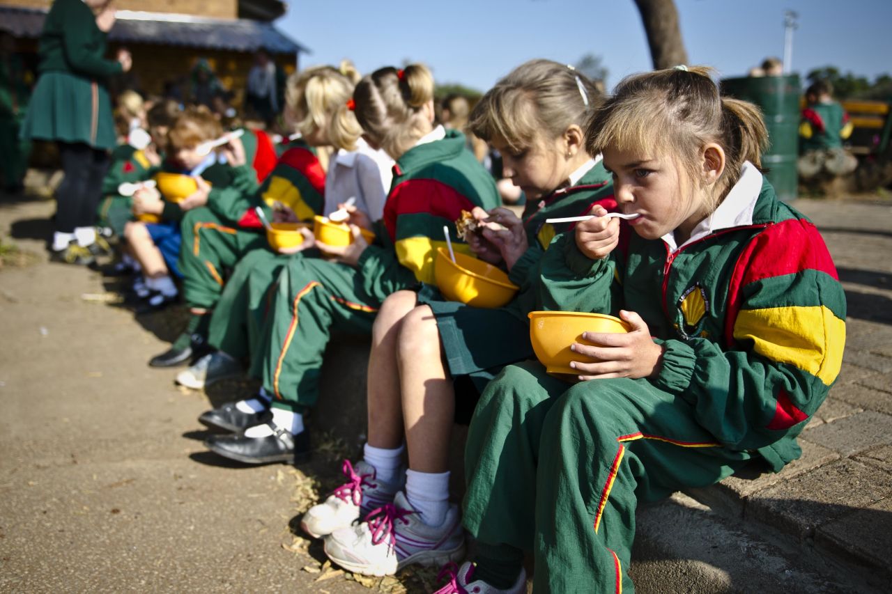 Students eat lunch at David Brink Primary School in Rustenburg, South Africa, where the number of students benefiting from the school's feeding program jumped from 65 to 185 students within a four-month period in 2014. During that time, many local mine workers and their families were under a lot of financial strain.