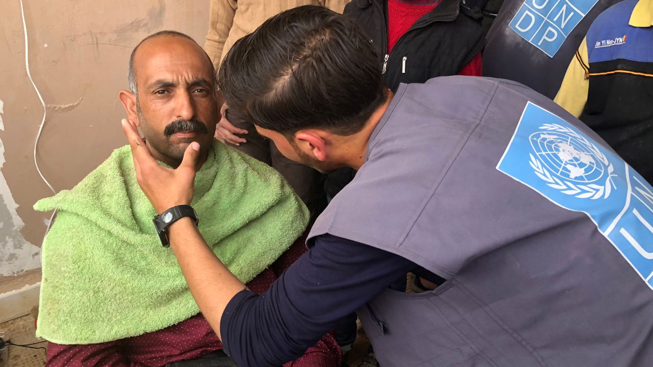 A man from Eastern Ghouta has his beard shaven in an open-air barber shop.
