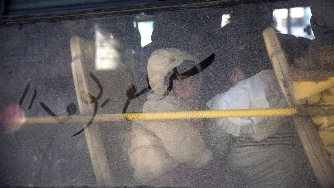 Arabic writing that reads "some day we will return" is seen on a bus window as civilians evacuate Aleppo on December 15, 2016. The evacuations began under a new ceasefire between rebels and pro-government forces.