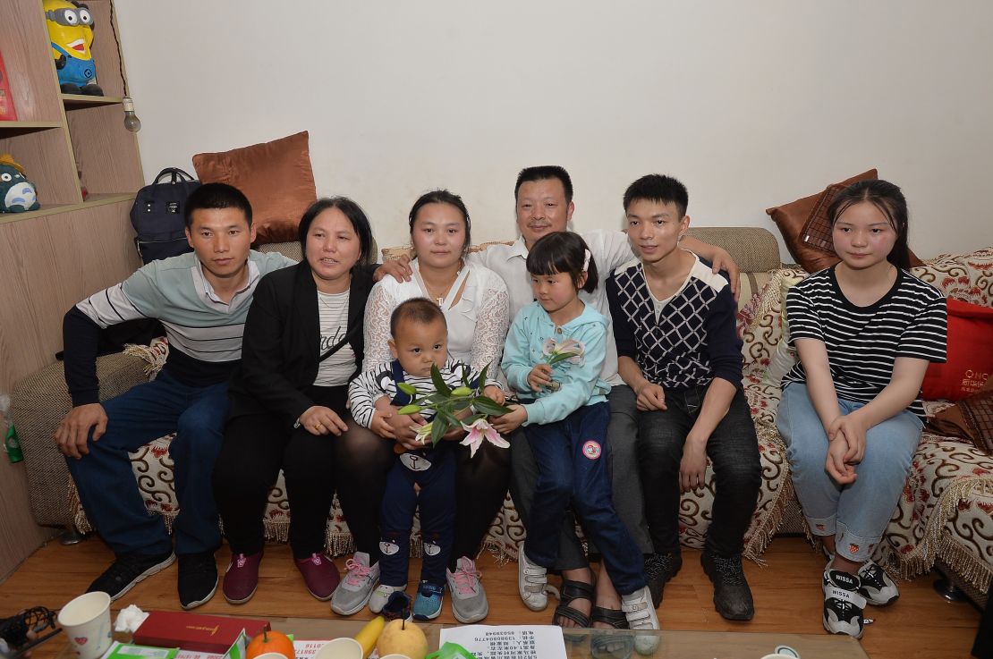 The families of Wang Mingqing and his missing daughter Kang Ying, second left, pose for photos after reuniting.