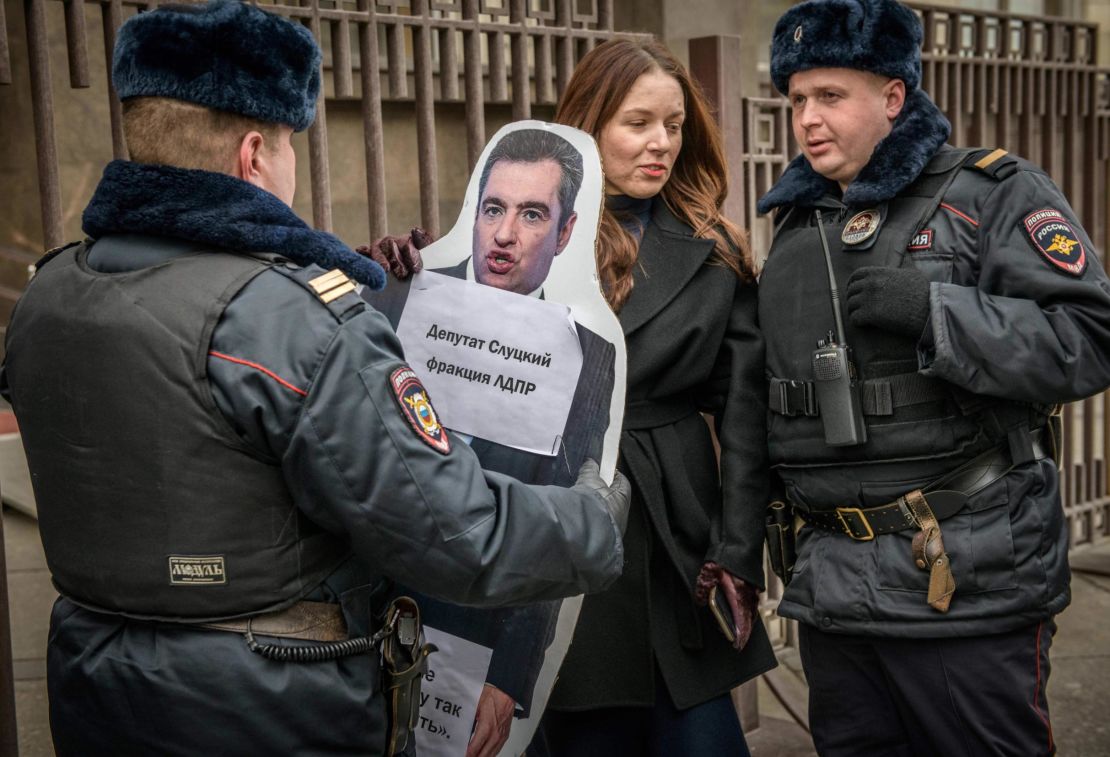 Russian police detain an activist  holding a cardboard cut out of Slutsky in front Moscow's State Duma on April 3.