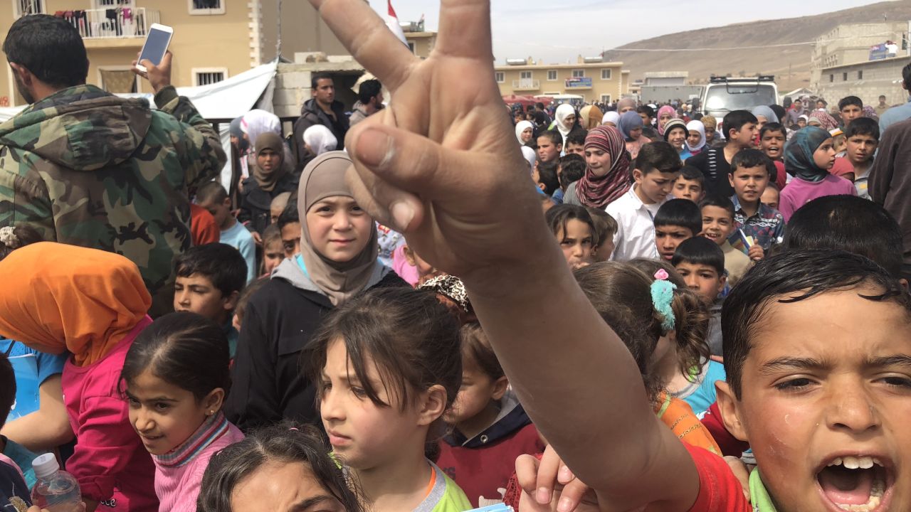 Hundreds of kids cross a bridge from a camp for internally displaced persons to go to school in a nearby village.