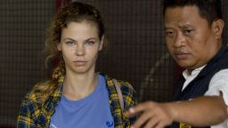 In this Feb. 28, 2018 photo, a police officer escorts Anastasia Vashukevich from a detention center in Pattaya, south of Bangkok, Thailand, after she was arrested Sunday in the Thai resort city of Pattaya while giving sex lessons to Russian tourists. Vashukevich told The Associated Press from a police van Wednesday that she fears for her life, and wants to exchange information on alleged Russian ties to U.S. President Donald Trump's campaign for her own personal safety. (AP Photo/Gemunu Amarasinghe, File)