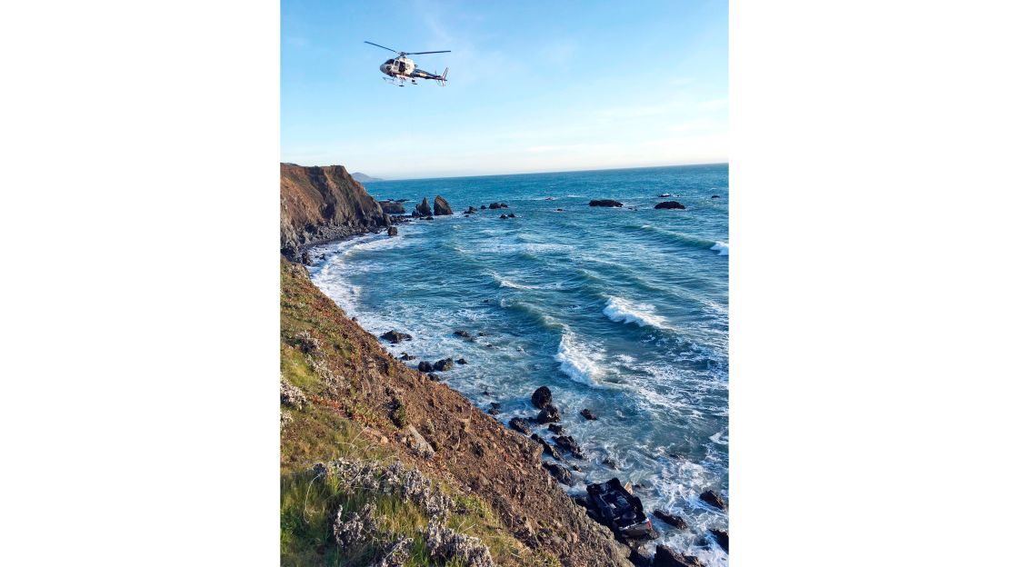 A helicopter hovers over a Mendocino County cliff where an SUV was discovered March 26.