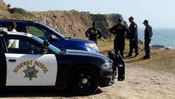 California Highway Patrol officers and deputy sheriffs from Mendocino and Alameda counties gather after a search for three missing children Wednesday, March 28, 2018, at the site where the bodies of Jennifer and Sarah Hart and three of their adopted children were recovered two days earlier, after the family's SUV plunged over a cliff at a pullout on the Pacific Coast Highway near Westport, Calif. Three of the children, Devonte Hart, 15, Hannah Hart, 16, and Sierra Hart, 12, have not been found. (Alvin Jornada/The Press Democrat via AP)