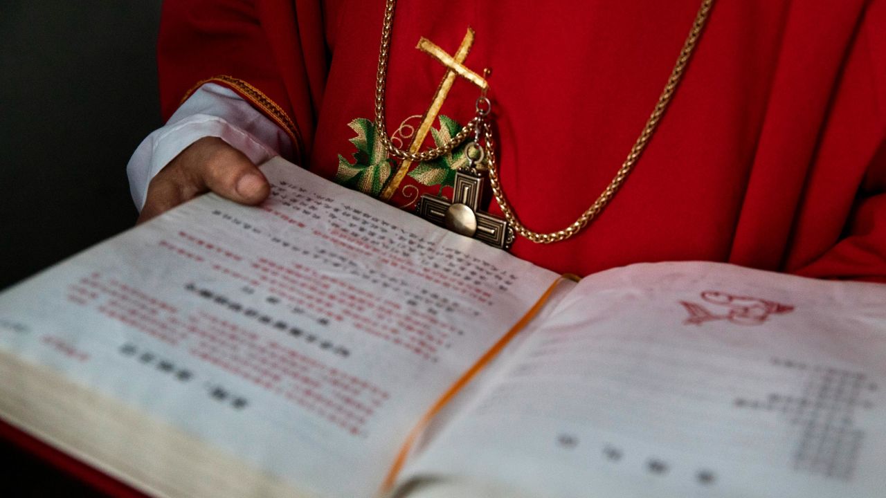 A Chinese Catholic deacon holds a bible at the Palm Sunday Mass during Easter Holy Week at an "underground" church  on April 9, 2017 near Shijiazhuang, Hebei Province, China.
