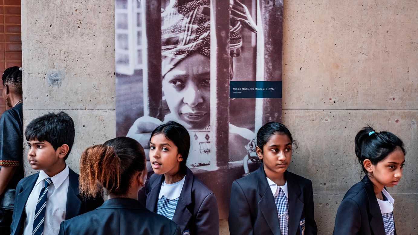 Schoolchildren pause under a portrait of <a href="http://www.cnn.com/2018/04/02/africa/gallery/winnie-mandela-life/index.html" target="_blank">Winnie Madikizela-Mandela</a> at her house in Soweto, South Africa, on Tuesday, April 3. Madikizela-Mandela, an anti-apartheid activist and former wife of Nelson Mandela, died Monday at the age of 81. The outspoken campaigner was known as the "Mother of the Nation" because of her struggle against white minority rule in South Africa. She was a member of the country's parliament at the time of her death.