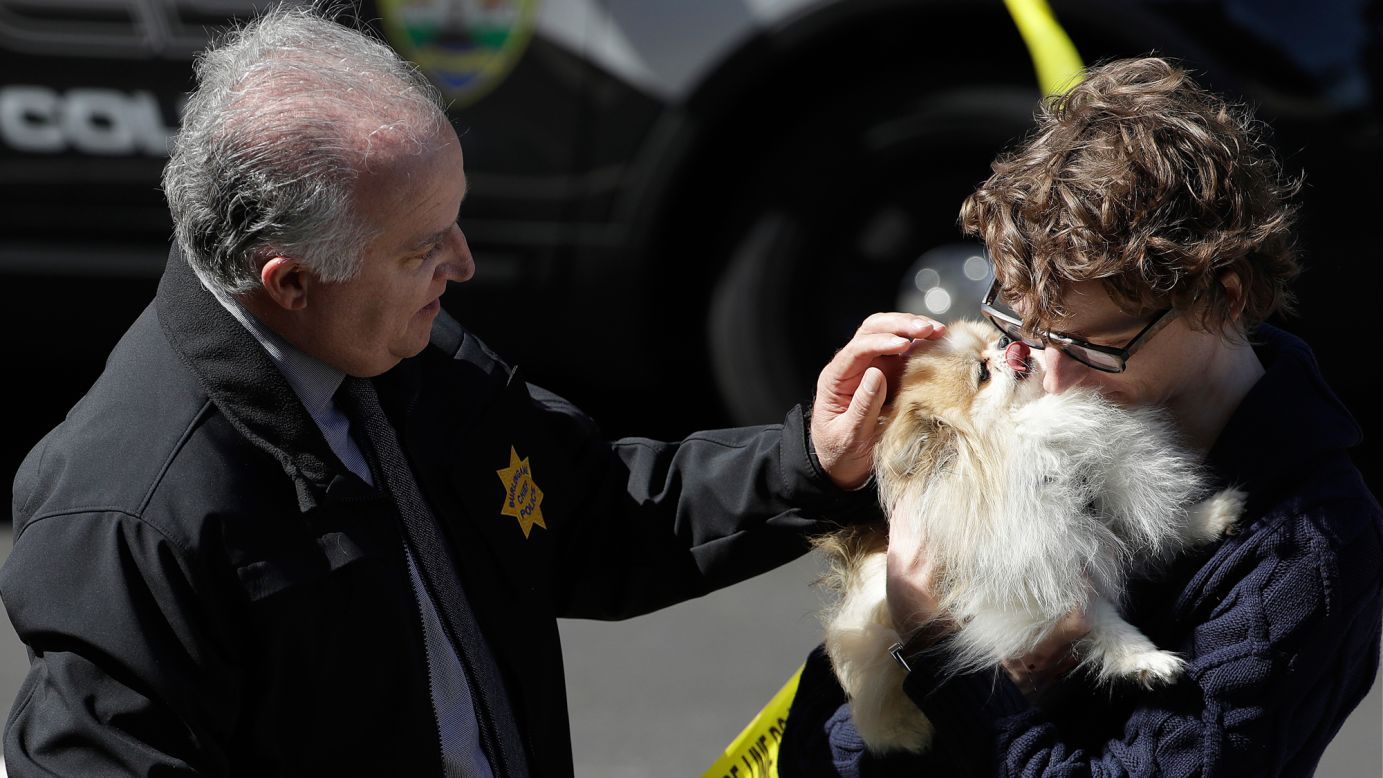 Burlingame Police Chief Eric Wollman hands a dog to a man outside YouTube headquarters, where <a href="https://www.cnn.com/2018/04/04/us/youtube-hq-shooting/index.html" target="_blank">a shooting took place</a> in San Bruno, California, on Tuesday, April 2. Nasim Najafi Aghdam shot and wounded three people before killing herself, police said. They said Aghdam was upset with YouTube's practices and policies.