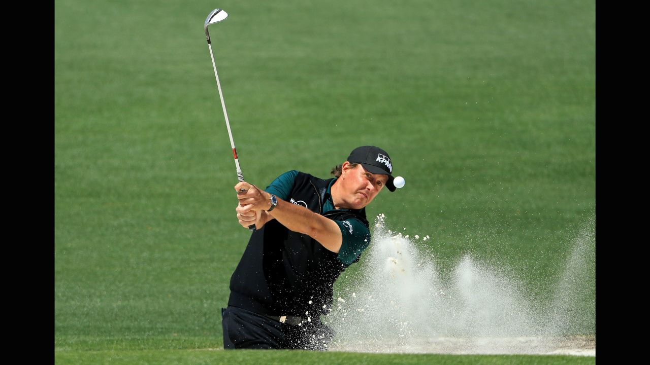 Phil Mickelson plays a shot from the bunker on Thursday.
