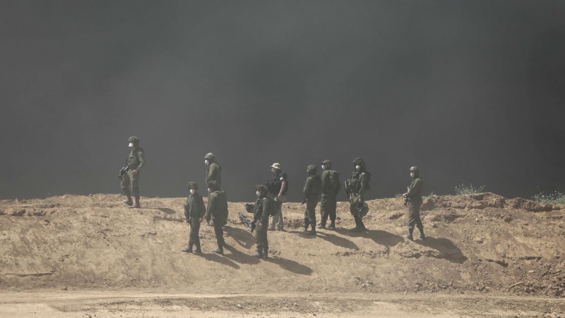 Israeli soldiers stand as smoke rises during protests at the Israel-Gaza border on Friday.