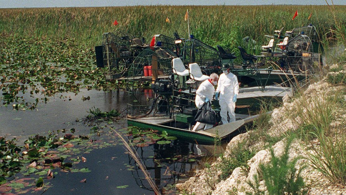 Hazardous materials team members remove a bag from an airboat on May 14, 1996, at the crash site area in the Florida Everglades.