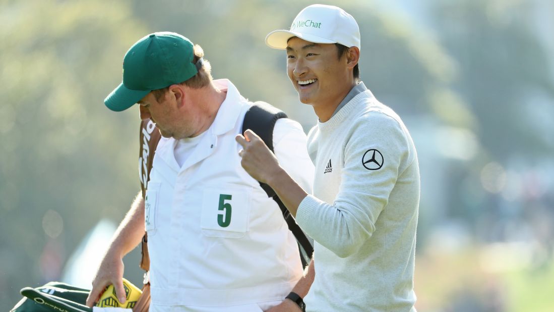 Haotong Li walks with caddie Michael Burrow on the first hole Friday.