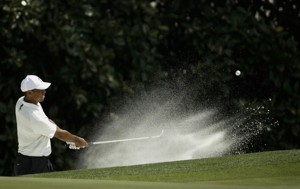 Tiger Woods hits a shot out of the bunker on Friday. The four-time Masters champion is playing in the tournament for the first time since 2015. He shot a 75 on Friday and is 4-over for the tournament, but it was good enough to make the cut.