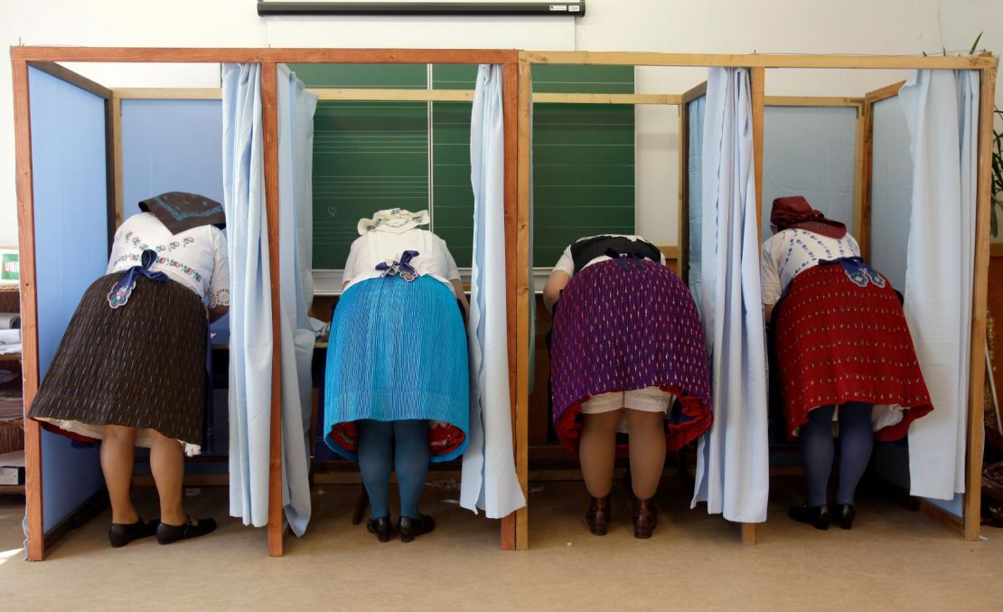 Women dressed in traditional Hungarian outfits cast their votes.  