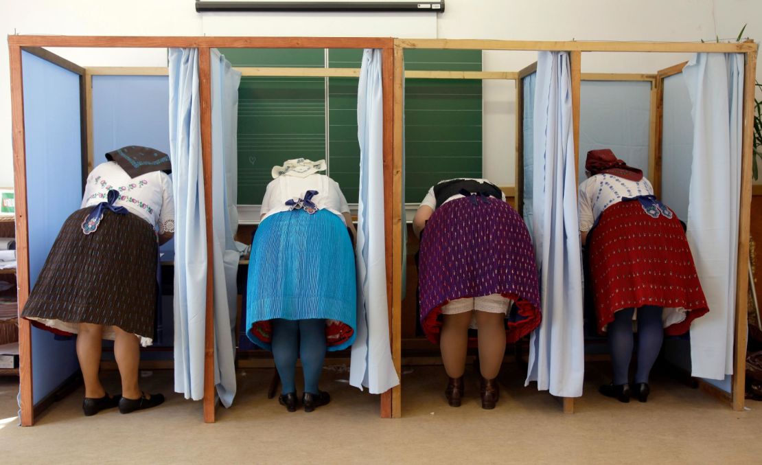Women dressed in traditional Hungarian outfits cast their votes.