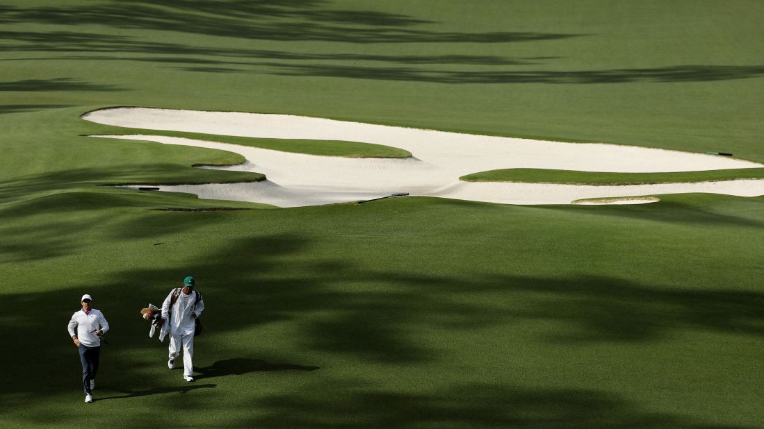 Rory McIlroy jogs up the tenth hole alongside caddie Harry Diamond.