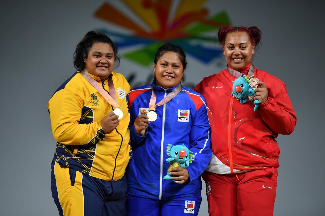 Silver medallist Charisma Amoe-Tarrant of Nauru, gold medallist Feagaiga Stowers of Samoa and bronze medallist Emily Campbell of England pose on the podium for the women's 90/+90kg weightlifting final at the Commonwealth Games.