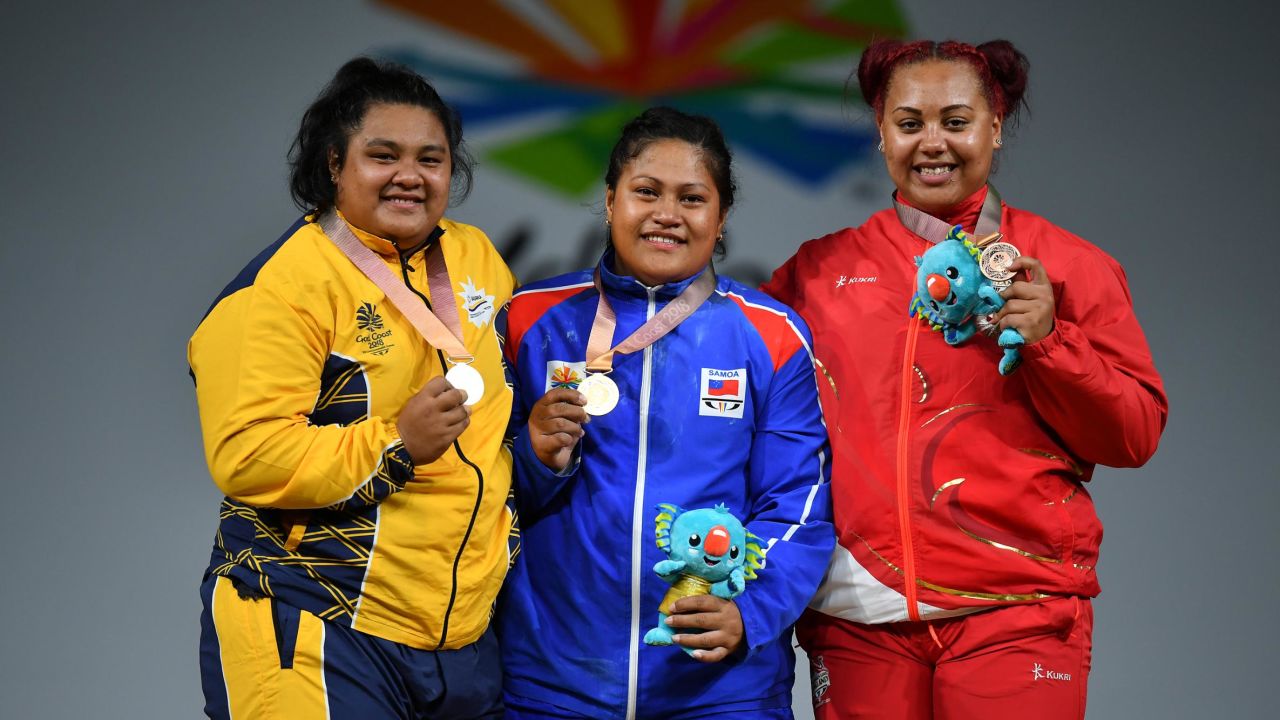 Silver medallist Charisma Amoe-Tarrant of Nauru, gold medallist Feagaiga Stowers of Samoa and bronze medallist Emily Campbell of England pose on the podium for the women's 90/+90kg weightlifting final at the Commonwealth Games.