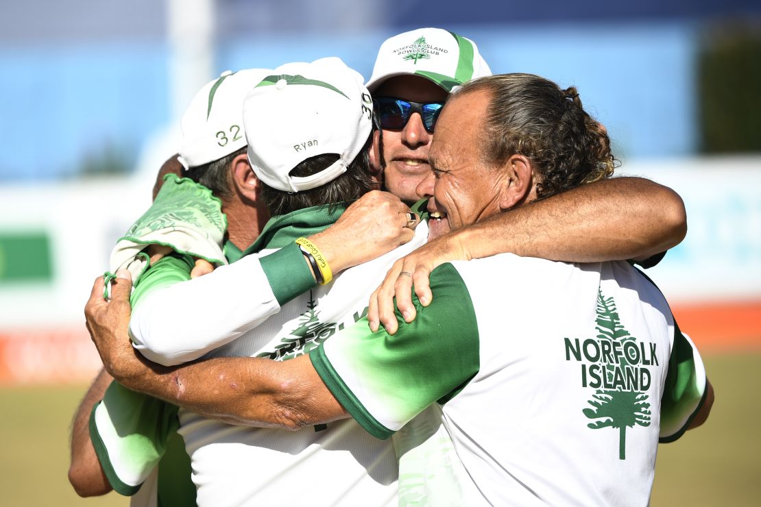 The Norfolk Island three-man lawn bowls team celebrate winning an historic bronze medal at the 2018 Commonwealth Games.