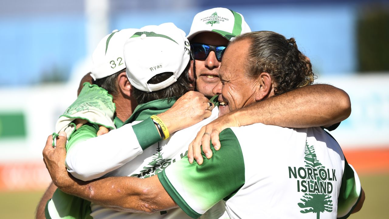 The Norfolk Island three-man lawn bowls team celebrate winning an historic bronze medal at the 2018 Commonwealth Games.