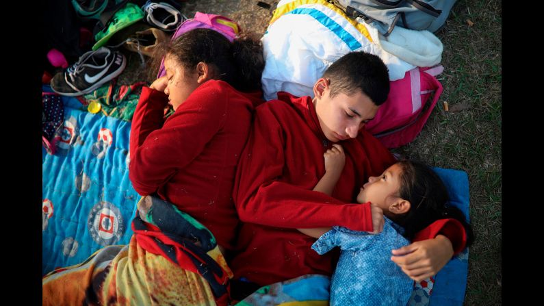 The Zelaya siblings -- from left, Daniela, Anderson and Nayeli -- huddle together on a soccer field in Matias Romero on Wednesday, April 4. Their father, Elmer, said the family is awaiting temporary transit visas that would allow them to continue to the US border, where they hope to request asylum and join relatives in New York. <a href="https://www.cnn.com/2018/04/06/us/mexico-caravan-migrants-stories/index.html" target="_blank">Related story: These are the migrants crossing Mexico</a>