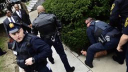 EDS NOTE: NUDITY - A protester is detained as Bill Cosby arrives for his sexual assault trial at the Montgomery County Courthouse, Monday, April 9, 2018, in Norristown, Pa. (AP Photo/Corey Perrine)