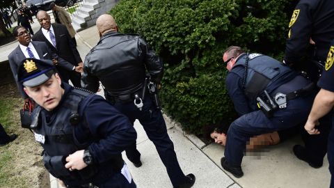 A protester is detained after Bill Cosby arrives for his sexual assault trial.