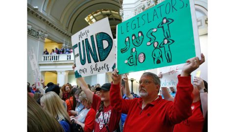 Teacher Eric Andexler, right, and his daughter Heather Andexler, who just graduated with a degree in early childhood education, protest Monday at the state Capitol.