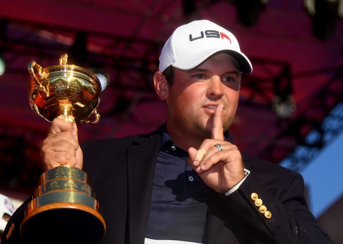 Reed gestures to the crowd while holding the Ryder Cup in 2016.