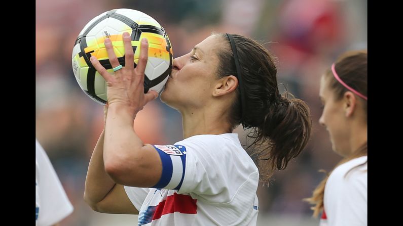 American soccer player Carli Lloyd kisses the ball after scoring her 100th international goal on Sunday, April 8. The United States defeated Mexico 6-2 in Houston.