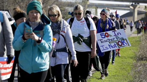 Teacher Taylor Painter-Wolfe carries a sign on her walk from Tulsa to Oklahoma City. 