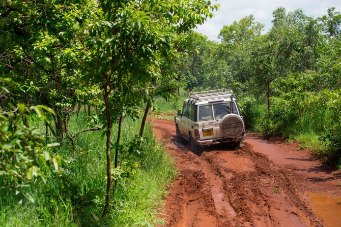 The elephant collaring ground team drive to another elephant herd along a dirt road in Mikumi National Park, Tanzania.