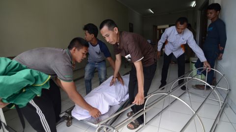 At a hospital in Cicalengka, West Java, family members on Monday move the body of a relative who died from drinking poisonous bootleg liquor.