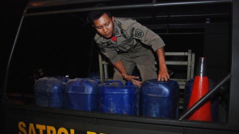 Indonesian police prepare to transport containers filled with illegal alcohol from a house in Cicalengka district in West Java province on Sunday.