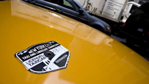 A New York City Taxi and Limousine Commission medallion sits on the hood of a taxi.
