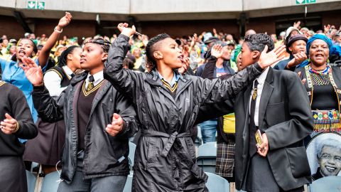South African students sing and dance with other mourners at the memorial service.