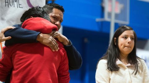 A student is comforted at a prayer vigil on Monday after talking about his mother's detention by ICE.