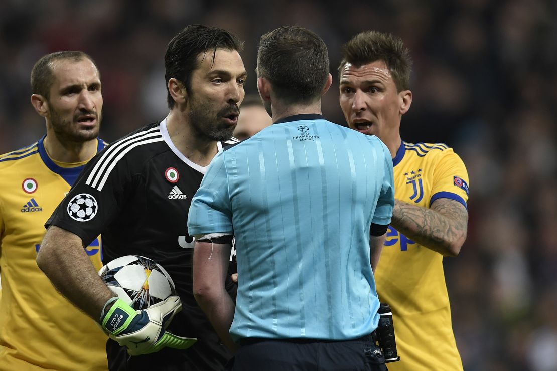 Buffon confronts referee Michael Oliver.