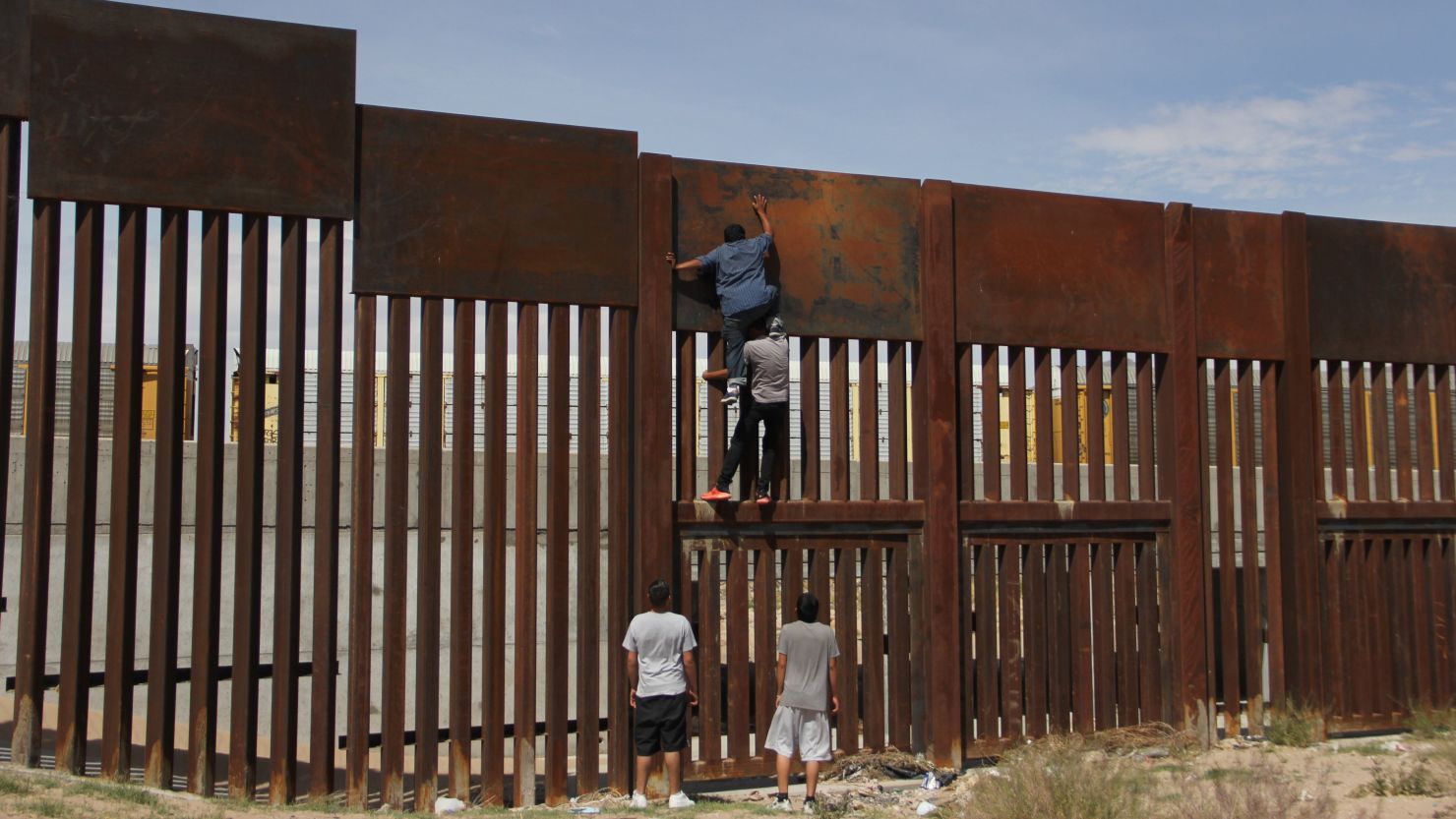 A young Mexican helps a compatriot to climb the metal wall that divides the border between Mexico and the United States to cross illegally to Sunland Park, from Ciudad Juarez, Chihuahua state, Mexico on April 6, 2018. (HERIKA MARTINEZ/AFP/Getty Images)