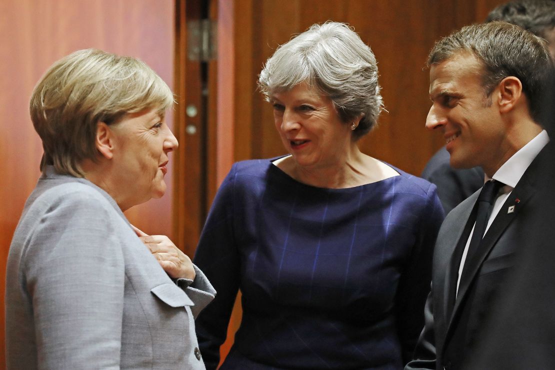 German Chancellor Angela Merkel, Britain's Prime Minister Theresa May and French President Emmanuel Macron arrive for a round table meeting on October 19, 2017 in Brussels, Belgium. 