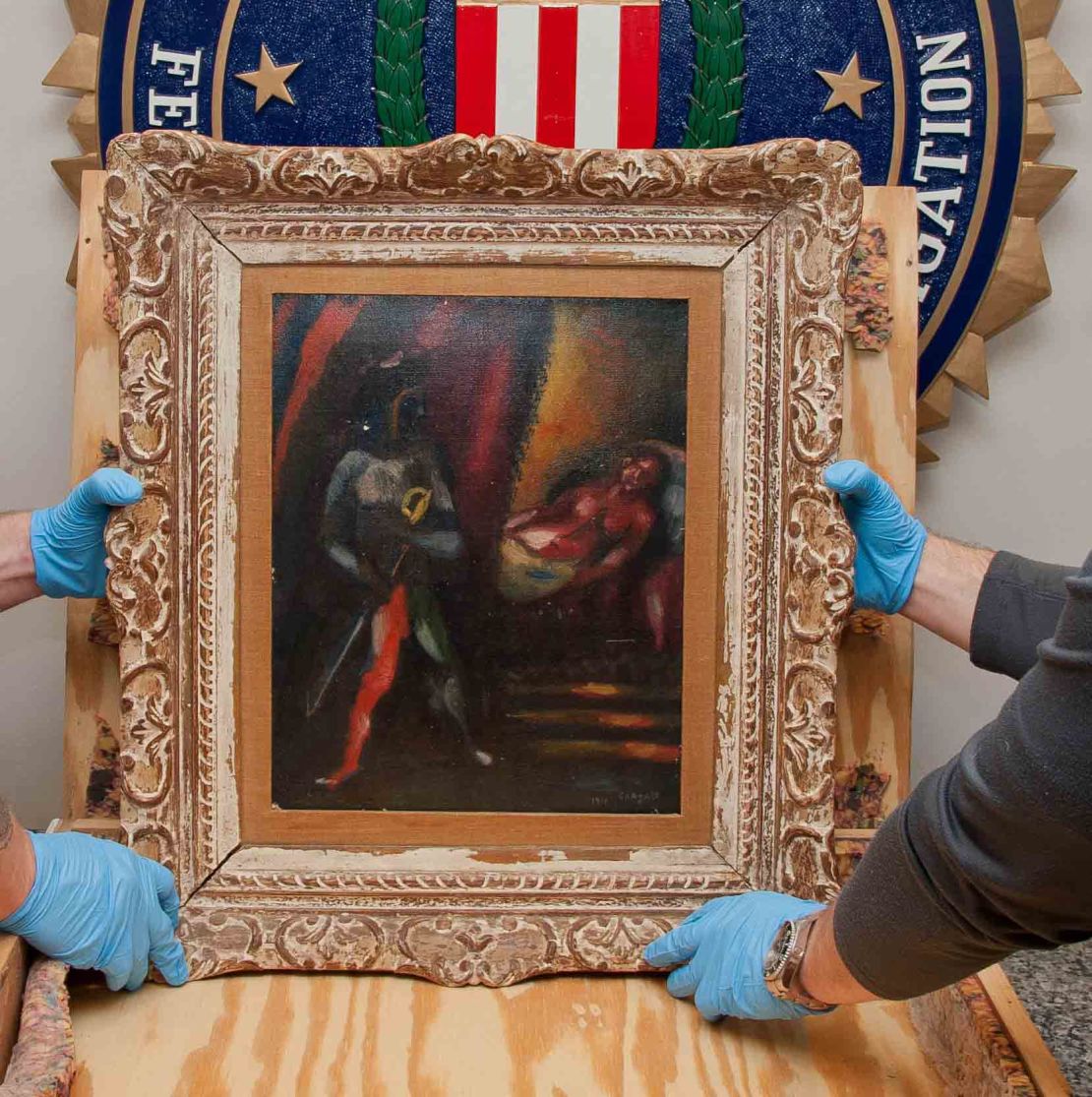 Personnel from the FBI's Art Crime Team handling the recovered Chagall painting, "Othello and Desdemona."
