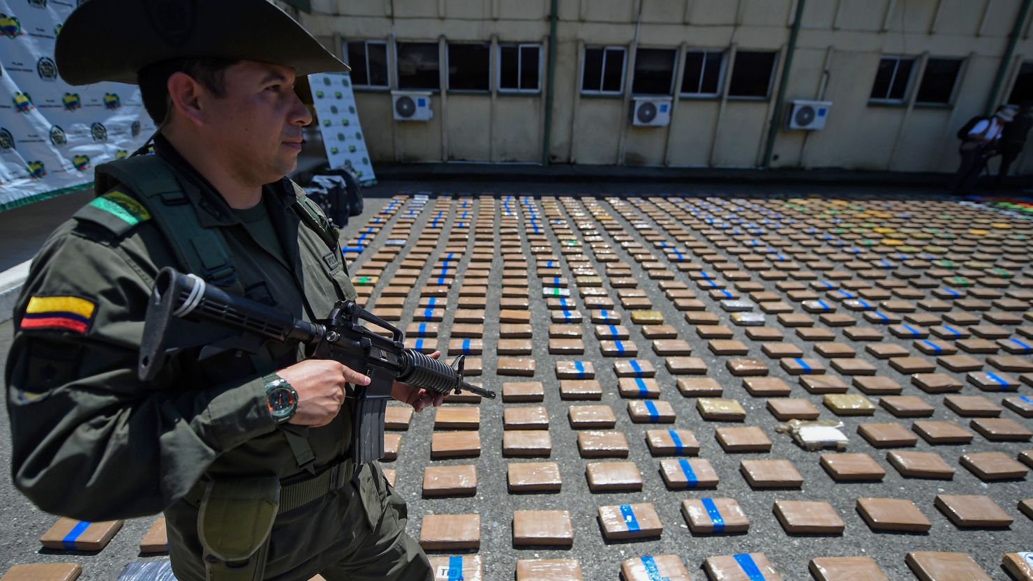 A member of the Colombian antinarcotics police, stands guard beside a one-ton shipment of cocaine seized to the country's biggest drug gang on August 10, 2017. (Credit :RAUL ARBOLEDA/AFP/Getty Images)