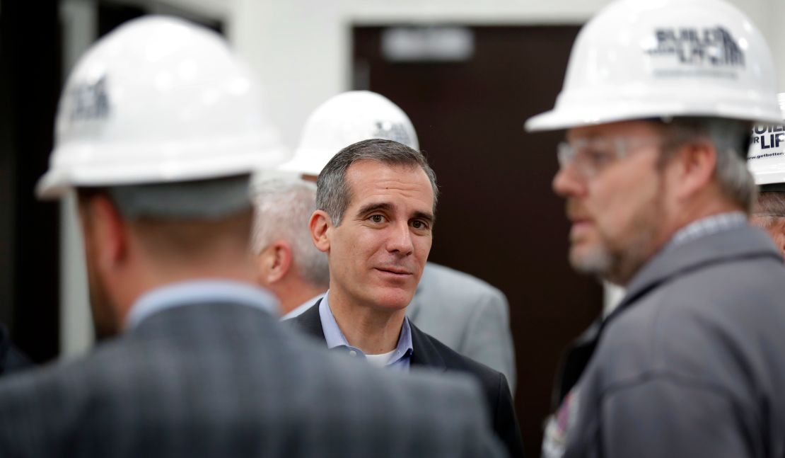 Los Angeles Mayor Eric Garcetti, center, visits with staff during a tour of a carpenters training facility on Friday, April 13, 2018, in Altoona, Iowa.