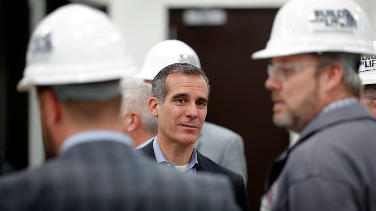 Los Angeles Mayor Eric Garcetti, center, visits with staff during a tour of a carpenters training facility on Friday, April 13, 2018, in Altoona, Iowa.