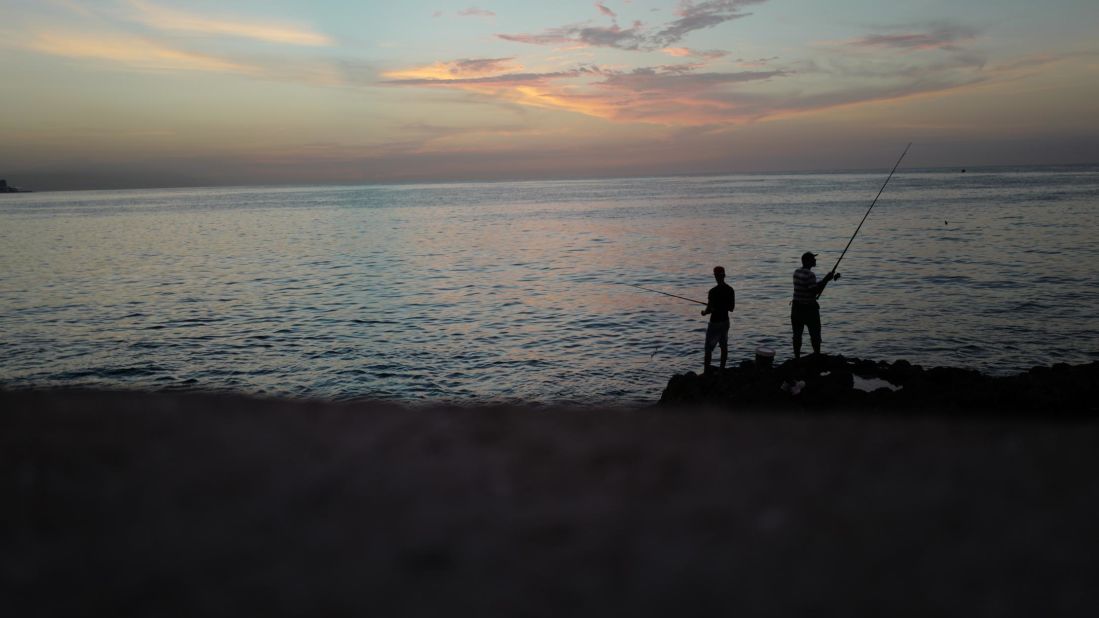 Cubans fish off Havana's Malecón seawall at sunset. The wall has been used during the years by Cubans launching small boats to attempt the dangerous journey across the Straits of Florida to the United States. Cubans who reached the US were allowed to stay there under the so-called "wet foot, dry foot" law that gave Cubans special immigration status. But in 2017, President Obama ended that policy and Cubans who reach the US are now being sent back to the island.