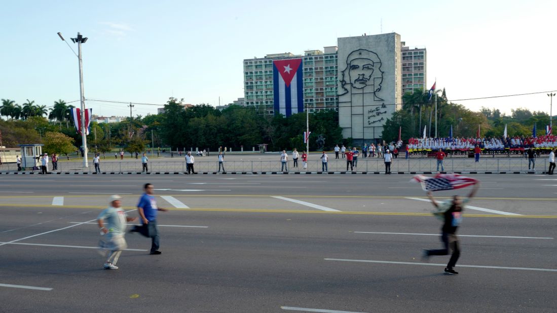 A protester carrying an American flag runs through Havana's revolution square on May Day 2017 ahead of a government-sponsored parade as plainclothes Cuban security agents try to catch him. International human rights groups criticize the Cuban government for repressing internal dissent. Cuban officials say the island's dissidents are "mercenaries" paid by Washington to stir up trouble.